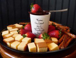 Tábua de queijos e morangos e canecas com chocolate