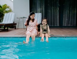 Duas crianças sentadas na beira da piscina
